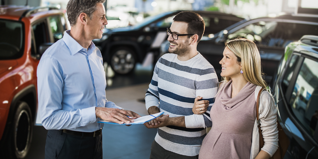 agent explaining car insurance policy to a couple